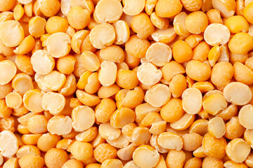 Uncooked, split, yellow peas background. Dry peas grains. Top view