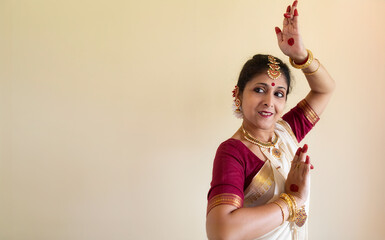 Female Indian classical dancer in Bharatanatyam dance mudra on white background with copy-space.