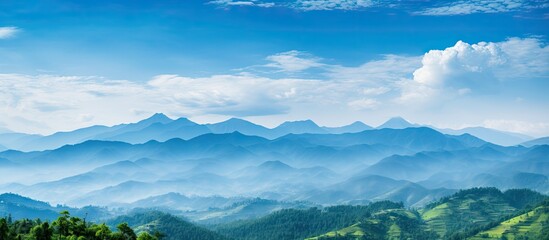 A picturesque landscape with rolling hills, verdant mountains, and a backdrop of a blue sky filled with fluffy clouds in a high-quality copy space image.