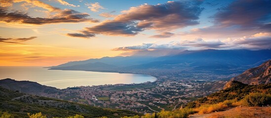 Beautiful highland mountain landscape at sunrise or sunset with majestic peaks, green and golden hills, against a backdrop of a cloudy sky, perfect for a copy space image.