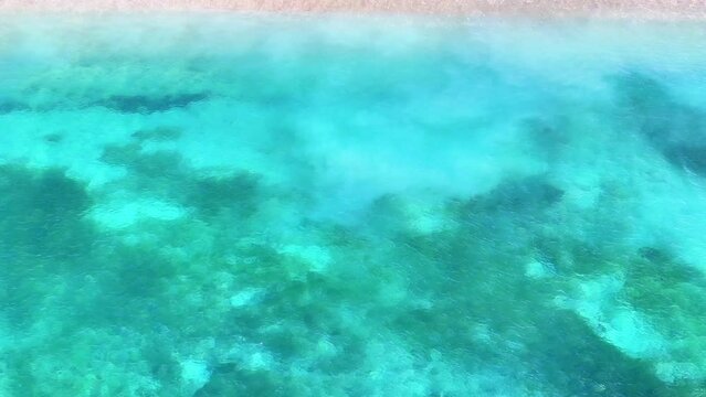 aerial view of clear water waves on white sand beach on tabuhan island banyuwangi east java indonesia. tourist destination in summer.
