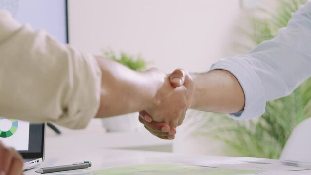close up handshake esg environment agreeement,cooperate partnership at green office