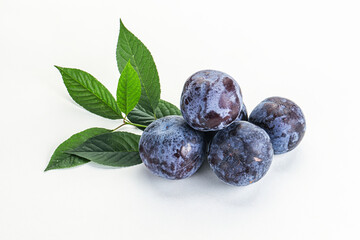 Raw purple plums heap with leaves