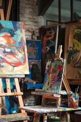Obraz premium A creative artist's studio with various artworks in progress, vibrant colors, and an inspiring atmosphere.