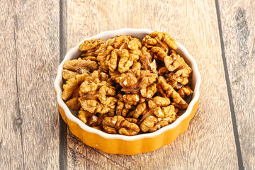 Cracked unshelled walnut in the bowl