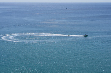 The boat rides tourists on tubing and completes a loop turn on the sea surface (Rhodes, Greece)