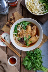 Stewed chicken noodle soup, chicken noodle soup in white bowl with Side of vegetables, asian food, thai food , chinese food, home made, top view food table