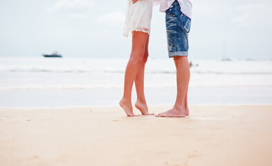 Close up male and female feet on the sand beach