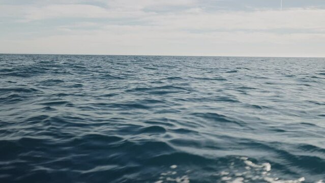 Slow motion side view of sea surface from a boat