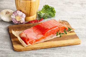 Raw salmon fillet over board
