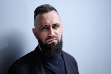 Studio portrait of young handsome man with beard.