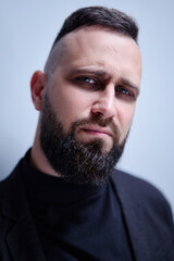 Studio portrait of young handsome man with beard.