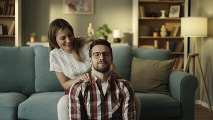Slow-motion shot of a husband receives neck massage from his caring wife. Felling relaxed while getting the massage