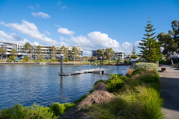 Waterfront of Maribyrnong River with a pedestrian walkway a public floating pontoon and residential apartment buildings. Beautiful and clean living environment in Melbourne's suburb of Maribyrnong © Doublelee