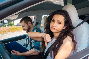 Male auto instructor taking exam in young woman. Failing exams. Driving test, driver courses, exam concept