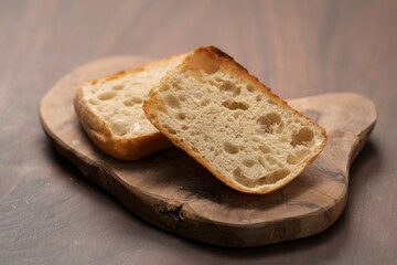 sliced ciabatta bun on wood board closeup