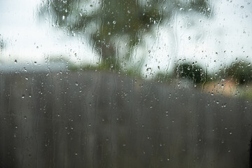 focus on raindrops on a window with a blurry background