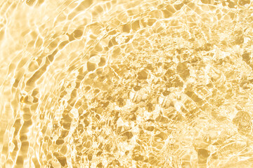 Water with shining ripple texture on a vibrant pastel yellow background. Abstract background idea.