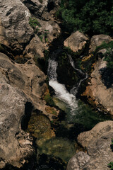 Small waterfall in Montenegro, in the old town of Bar. A clear, transparent mountain river flows down the rocks into the gorge. Top view.