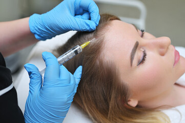 A dermatologist cosmetologist performs a mesotherapy procedure and injects an injection into the...