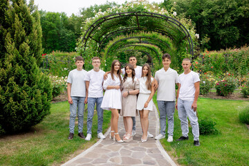 A group of young people posing for a picture in a park. Scene is happy and friendly