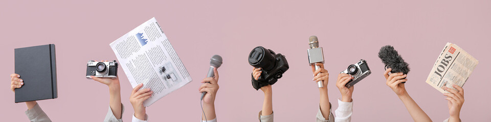 Female hands with newspaper, notebook, microphone and photo camera on color background