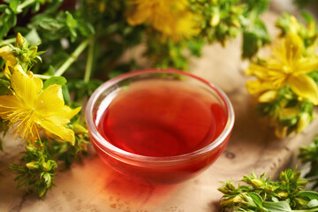 Red oil made from St. John's wort flowers in a bowl