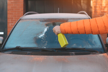 man cleaning car windows of snow and ice Toned image