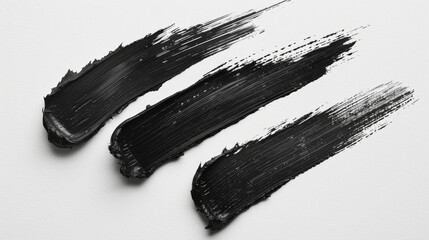 Set of 3 black brush strokes side by side over white paper 