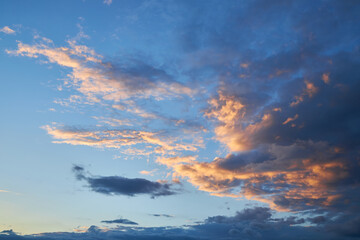 Obraz premium A fragment of a bright sunset sky with bizarrely shaped clouds