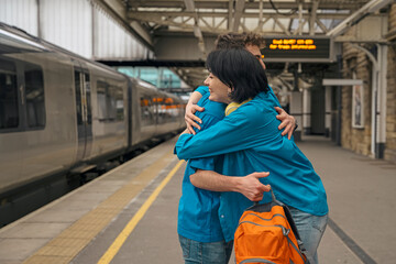 couple at railway station meeting hugging waiting for  train on platform  