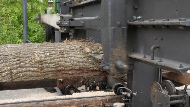 Antique Diesel-Powered Sawing Machine Cutting a Log into Slices, Close-Up