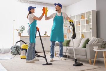 Janitors giving each other high-five after cleaning carpet in room