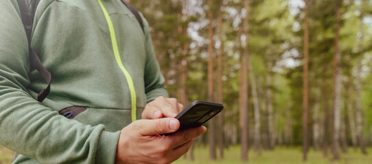 person using cell phone in the forest
