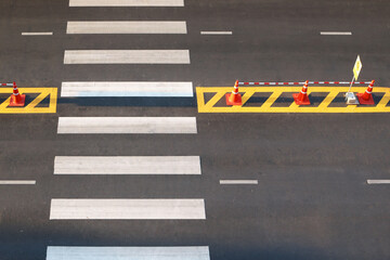 Pedestrian crossing with white marking lines on asphalt road aerial top view.