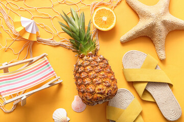 Fresh pineapple with orange, starfish , flip flops and deck chair on color background