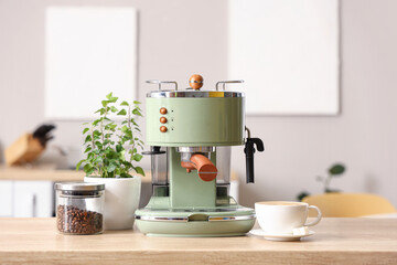 Modern coffee machine, beans and cup of espresso on wooden table in kitchen