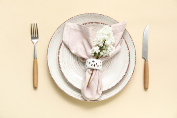 Beautiful table setting with lilac flowers on beige background