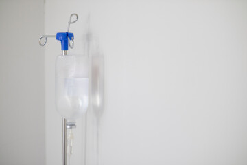 Bottles saline are hung on poles for giving saline patients and passing them through an intravenous line on patient bed. Medical which doctor gives saline solution patient through an intravenous