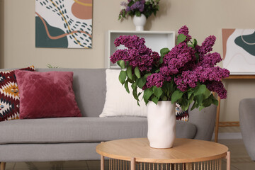 Lilac flowers in vase on coffee table in living room