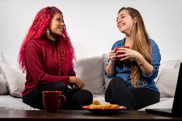 Par de amigas teniendo una charla de chicas en el living de su casa