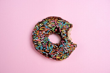 Delicious donut with a colorful sprinkle decoration bitten