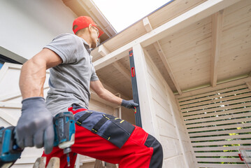 Construction Worker Using Level on Wooden Structure