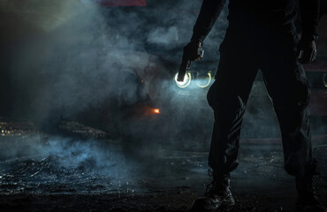 Silhouette of a Person Holding a Flashlight in Smoky Nighttime Setting