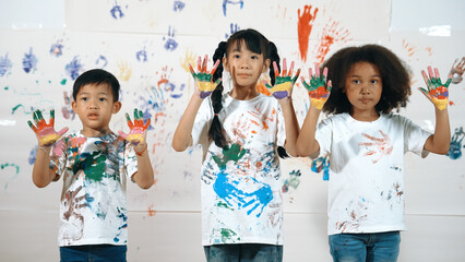 Diverse students put hands up together show colorful stained hands. Group of multicultural learner...