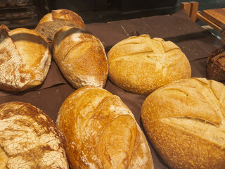 Different buns of fresh bread on a brown vintage background. Freshly baked wheat bread, still life with bread