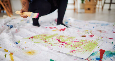 Floor, mess and hands with paper, painting and artist with brush for artwork, creative and art. Home, person and watercolor for supplies, painter and talent in apartment, palette and inspiration