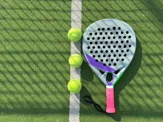 paddle tennis racket and balls on court 