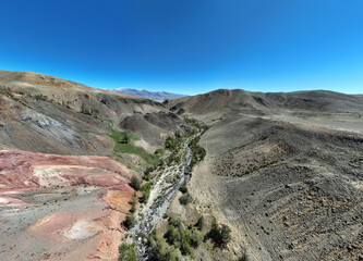 panoramic landscape with unusual red mountains with a Martian view filmed from a drone in Altai in May