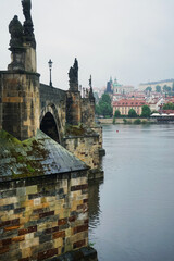 Charles Bridge from the side with Prague Castle in the background in gloomy rainy weather